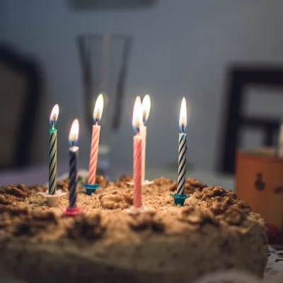 Geburtstagskuchen mit brennenden Kerzen